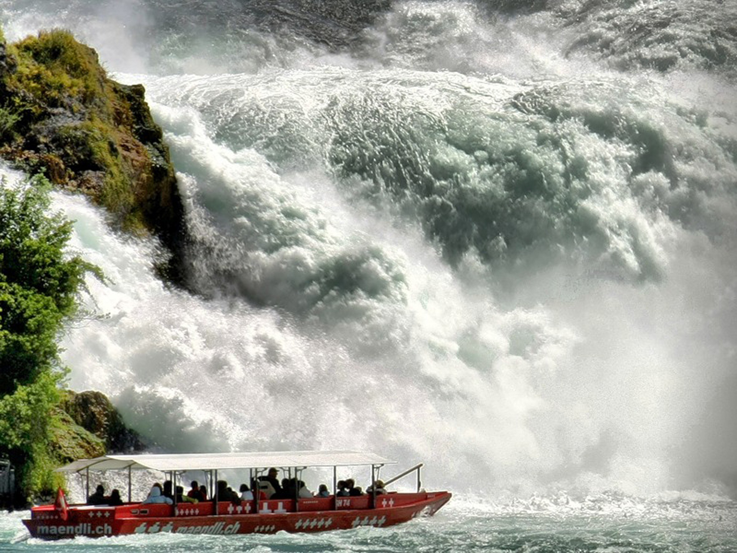 Boat near a powerful waterfall
