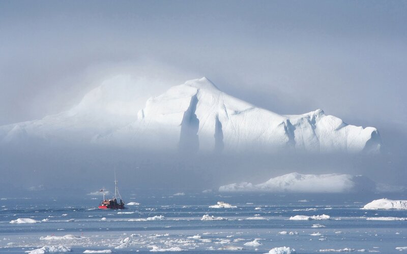 Boat near iceberg in fog