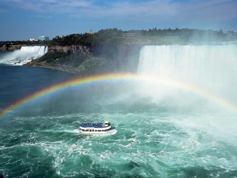Boat near Niagara Falls with rainbow