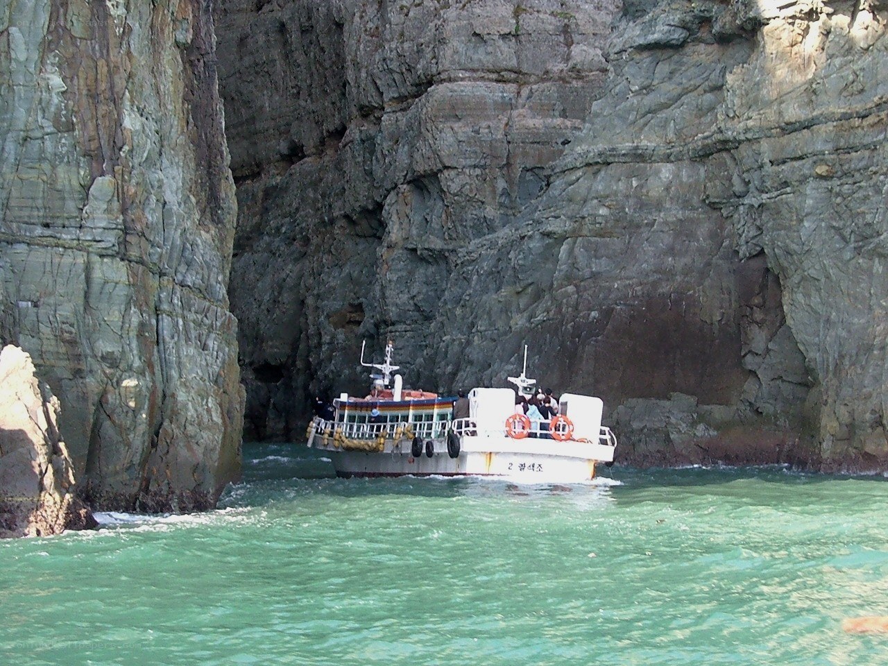 Boat near rocky cliffs