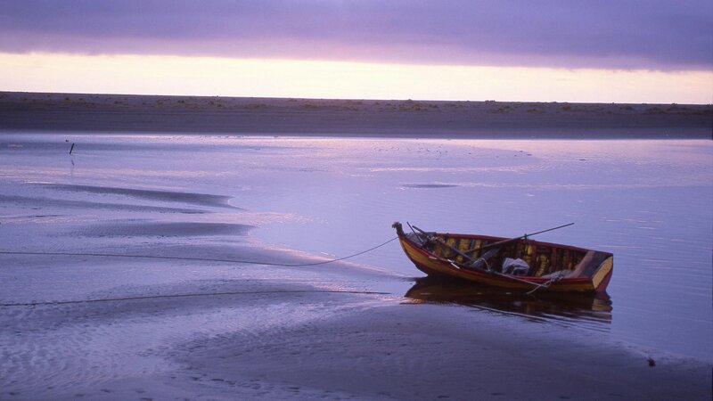 Boat on a calm beach at dusk