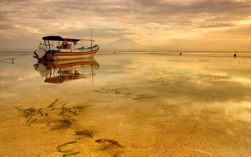 Boat on a calm beach at sunset