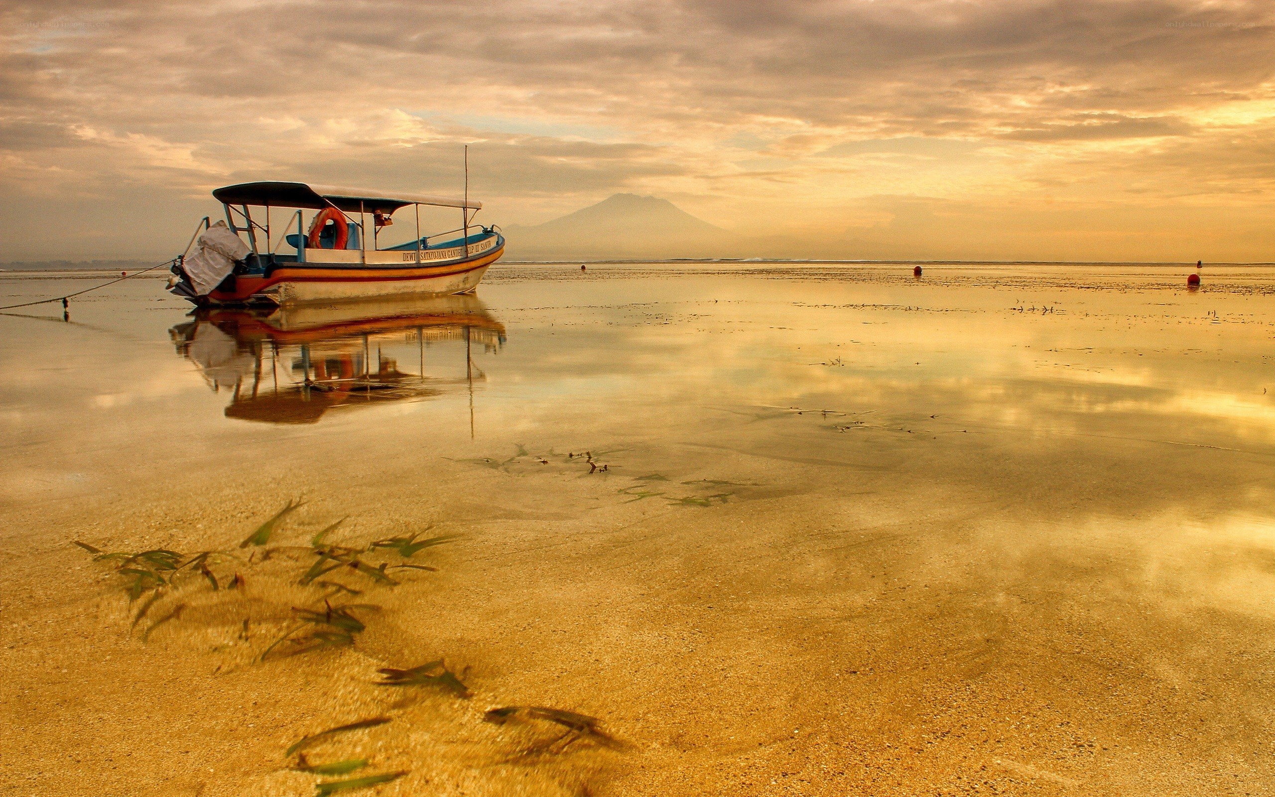 Boat on a calm beach at sunset