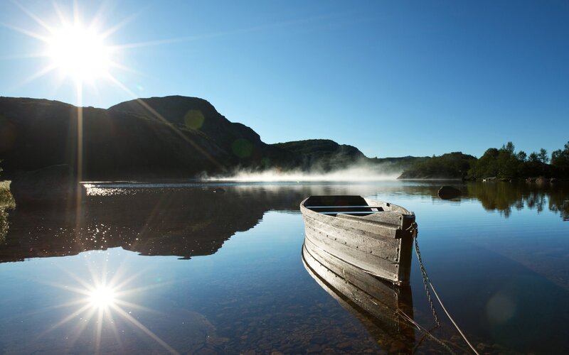 Boat on a misty lake at sunrise
