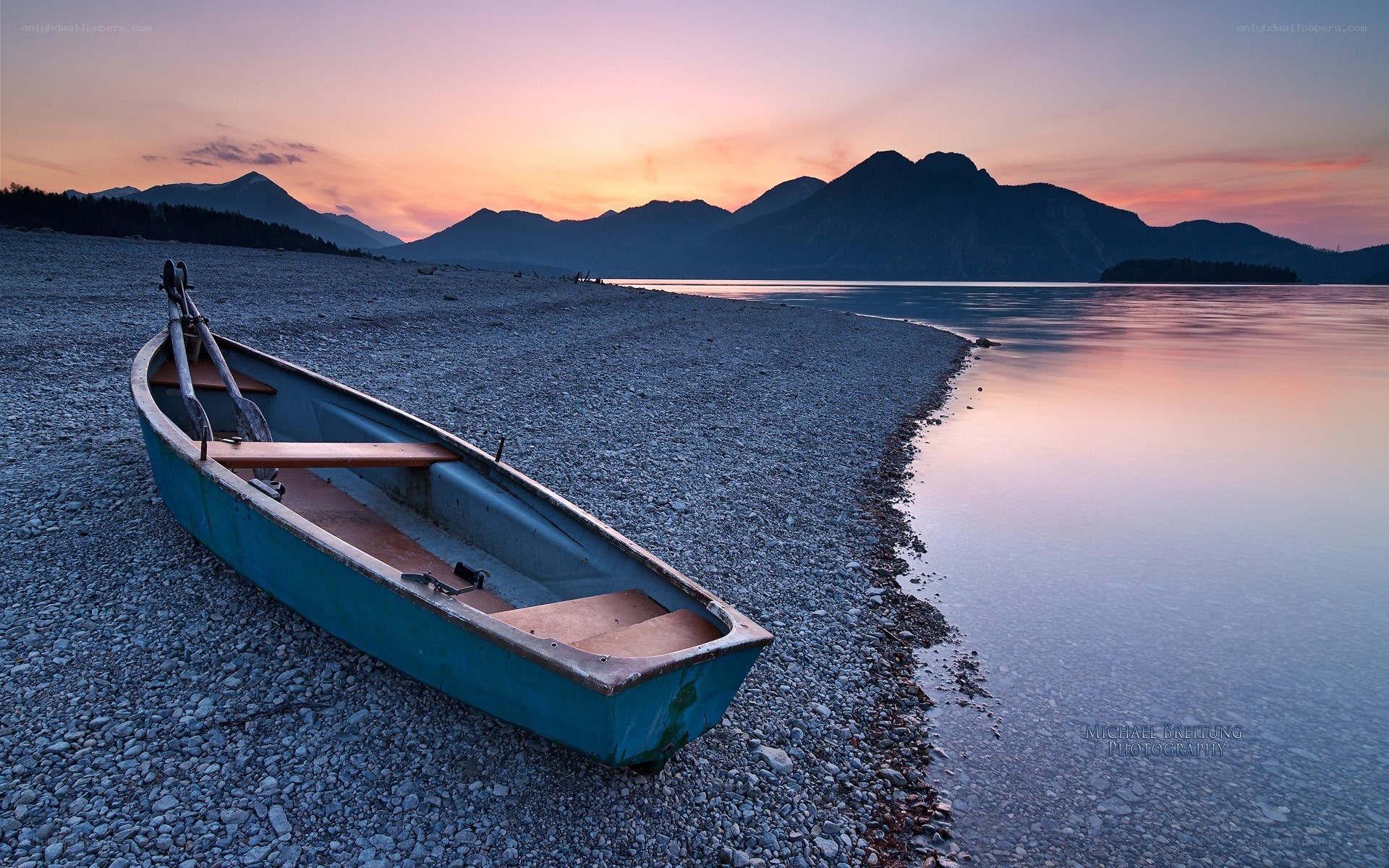 Boat on a pebble beach at sunset