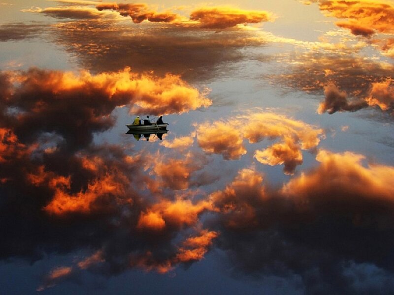 Boat on a reflective lake at sunset