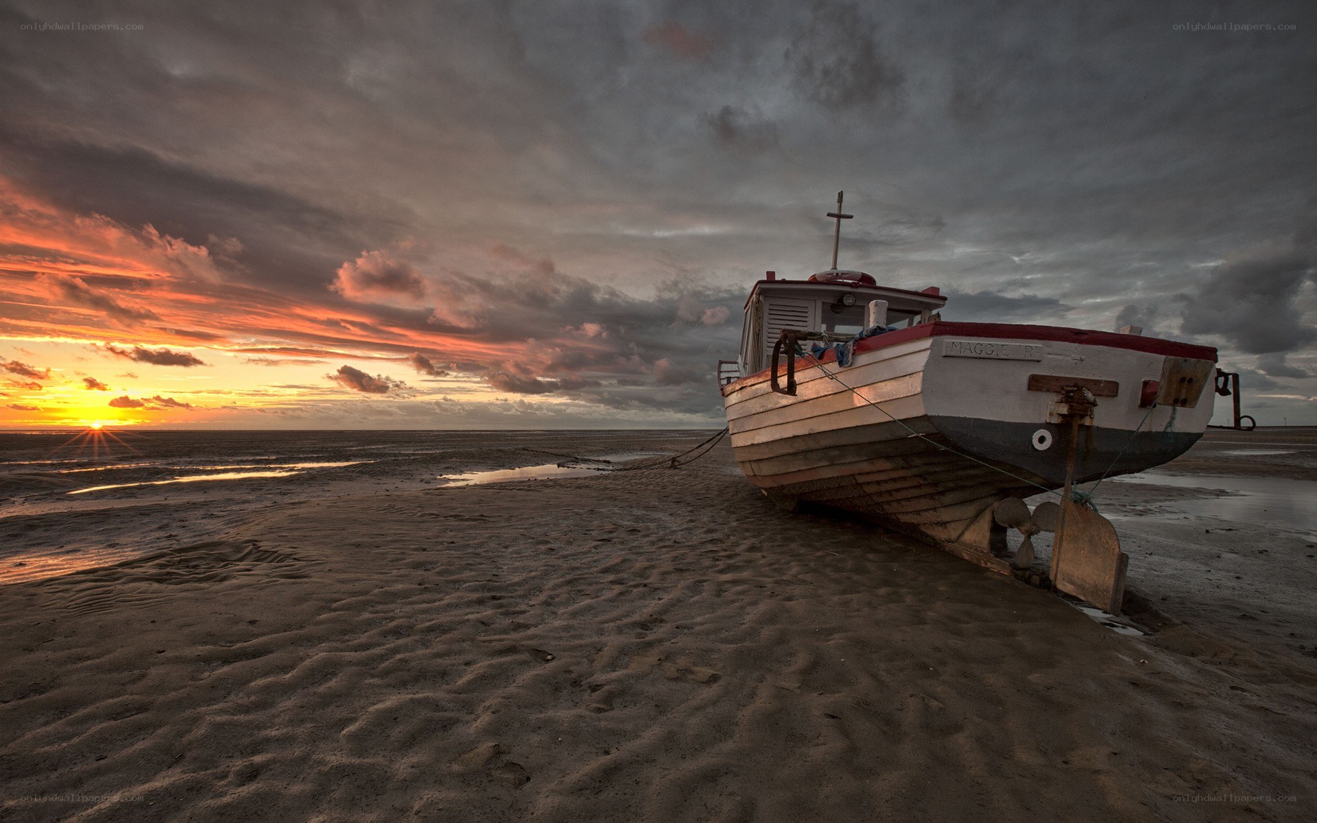 Boat on beach at sunset