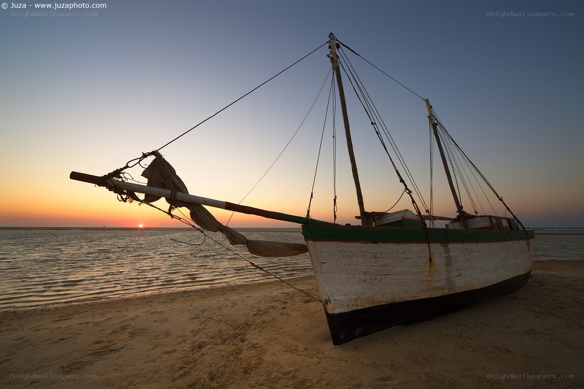 Boat on beach at sunset