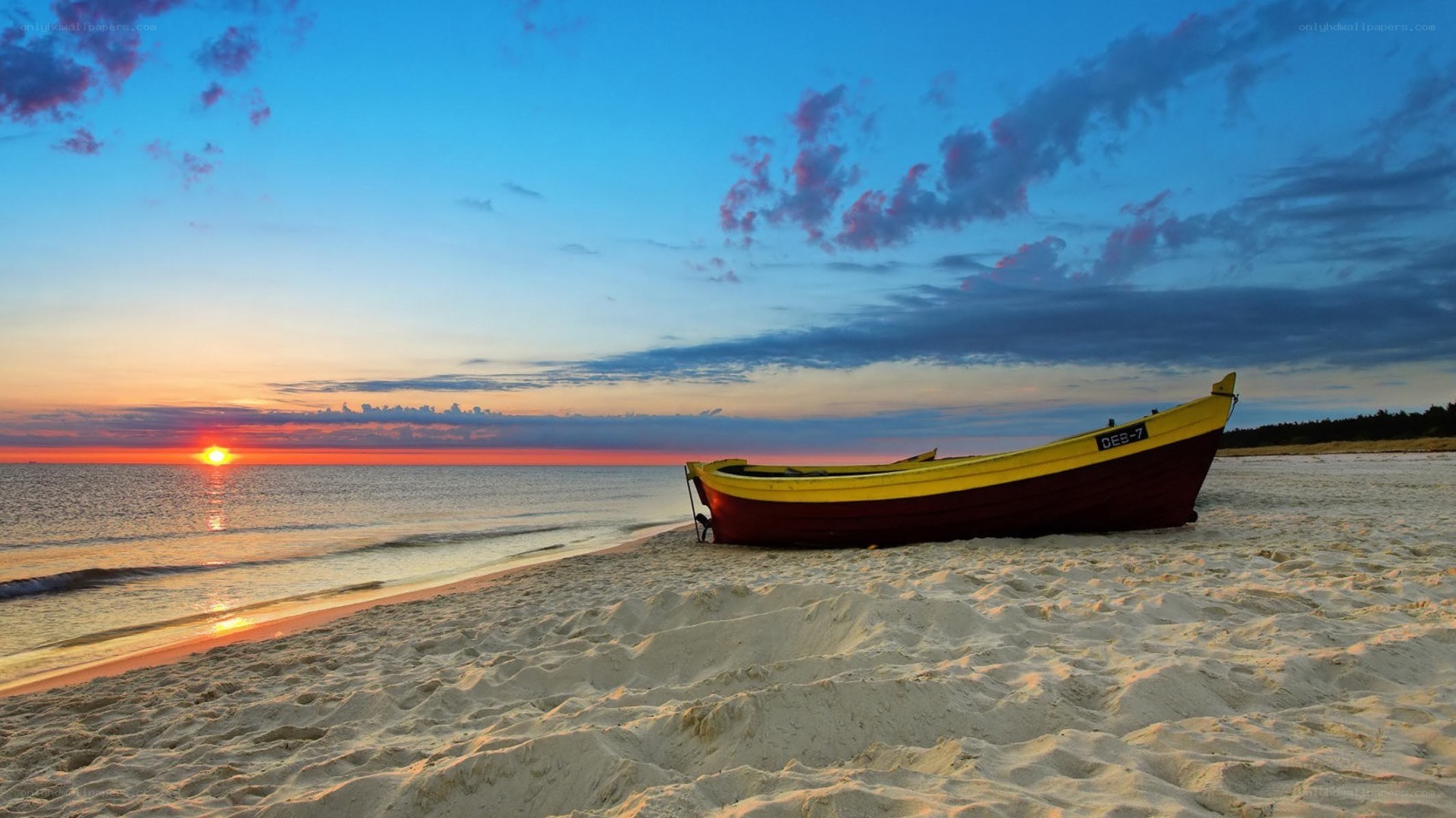 Boat on beach at sunset