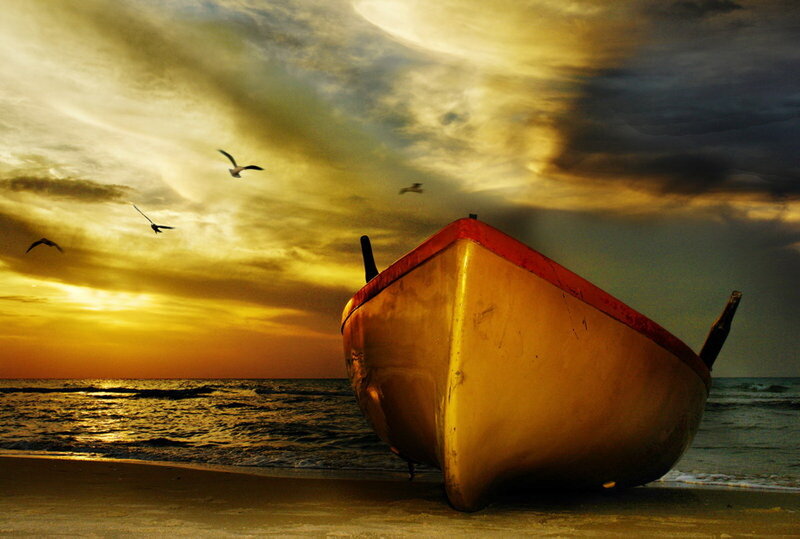 Boat on beach at sunset