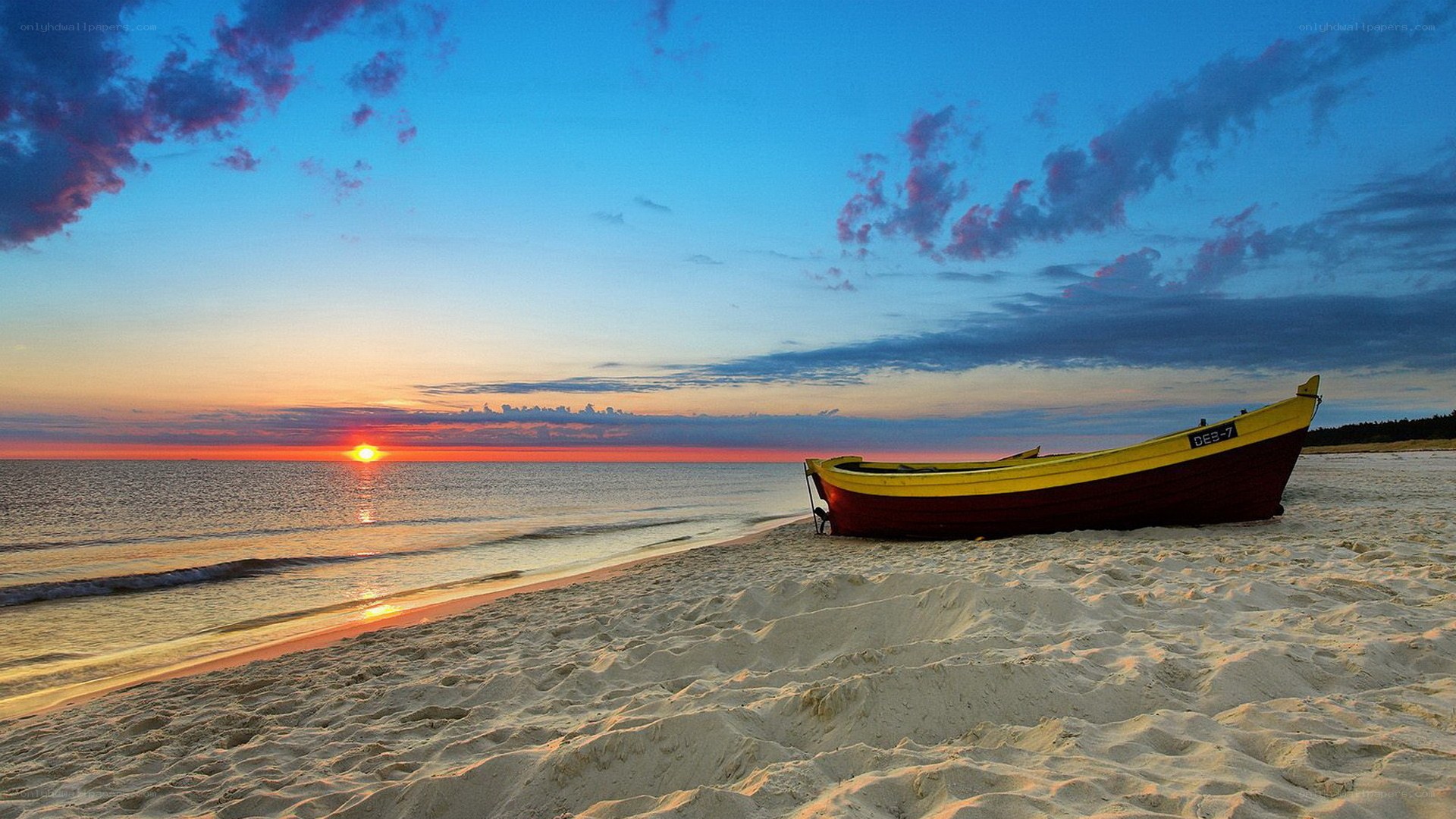 Boat on beach at sunset