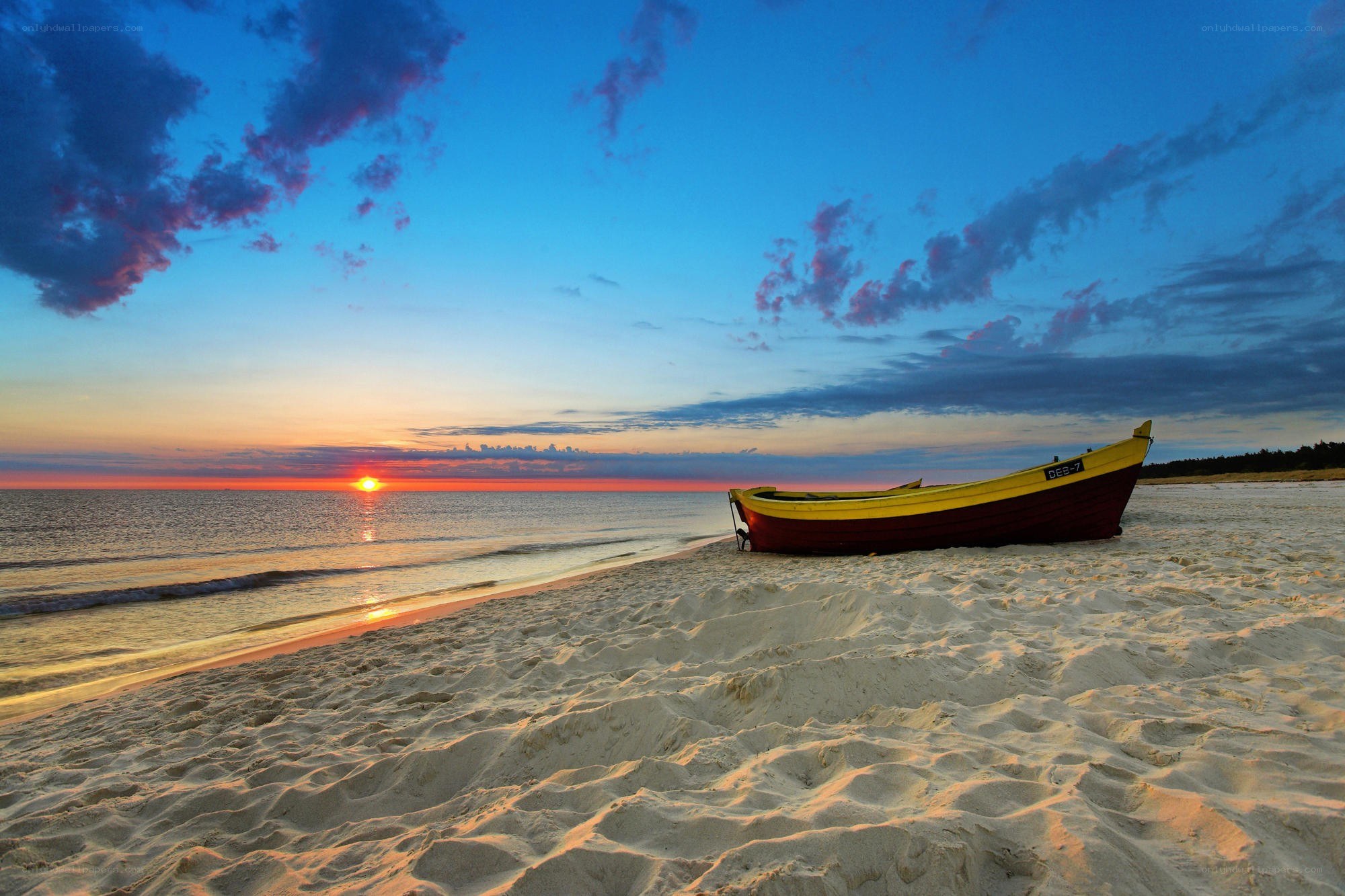 Boat on beach at sunset