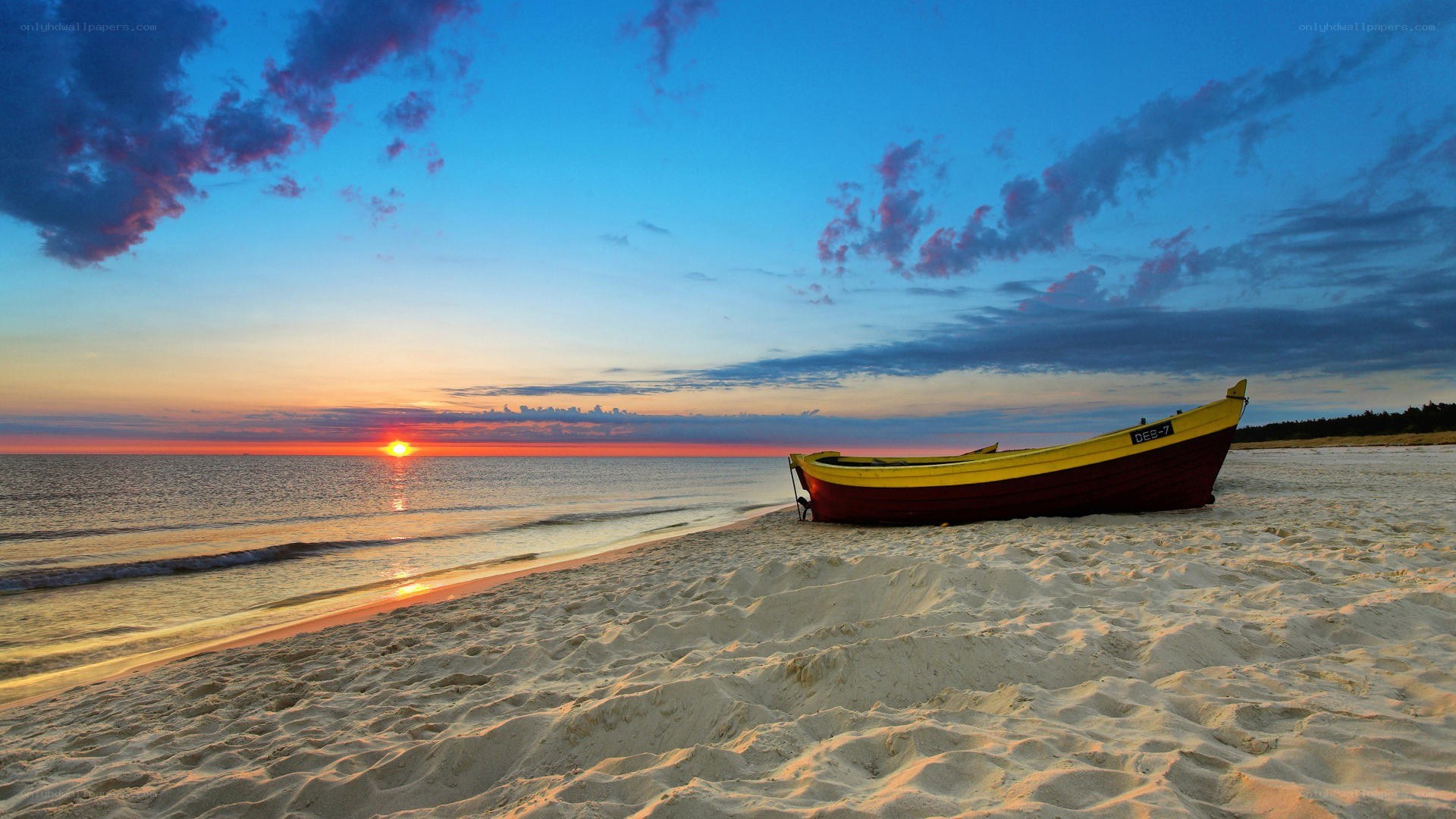 Boat on beach at sunset