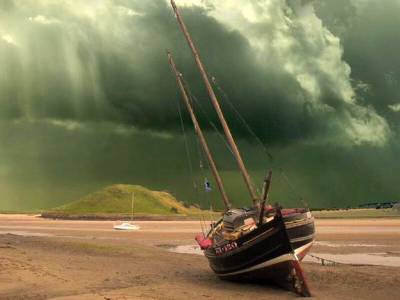 Boat on beach under stormy sky