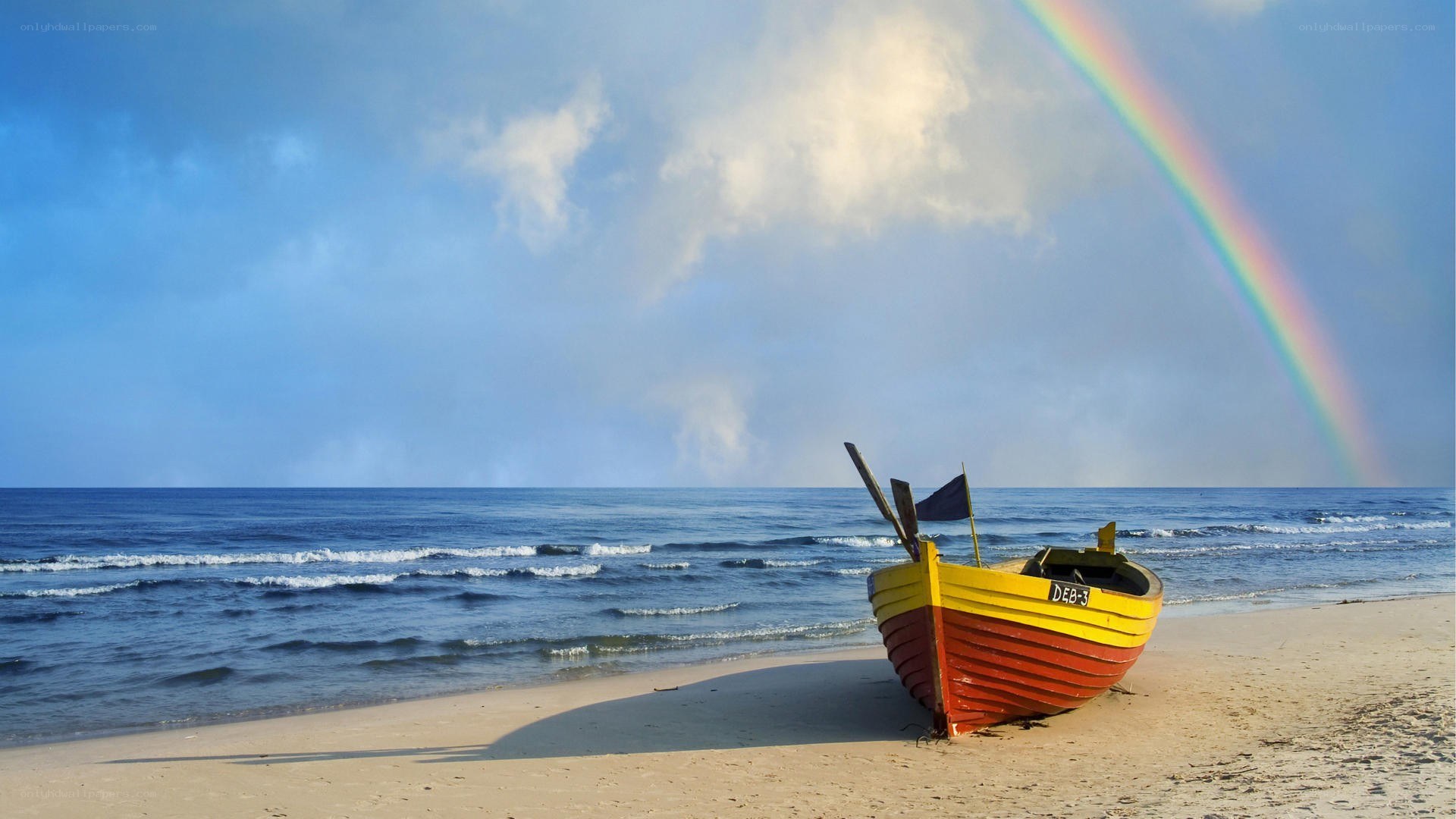 Boat on beach with rainbow