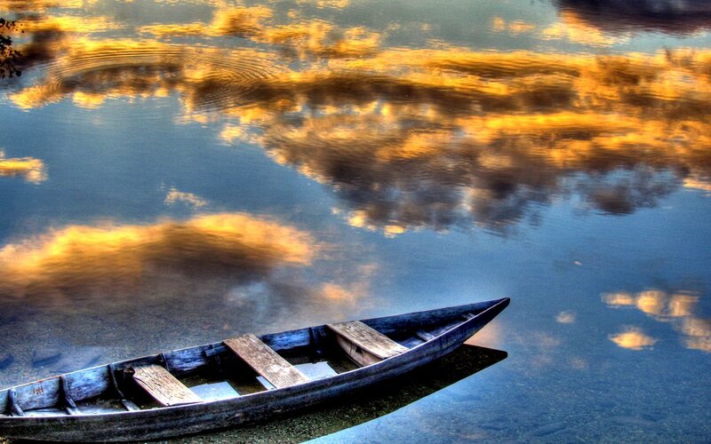 Boat on calm water at sunset