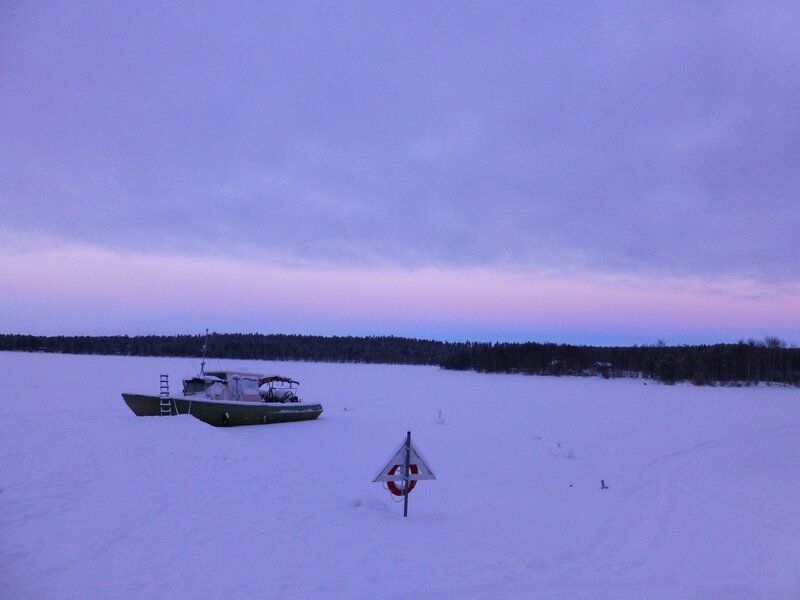 boat on frozen lake at dusk
