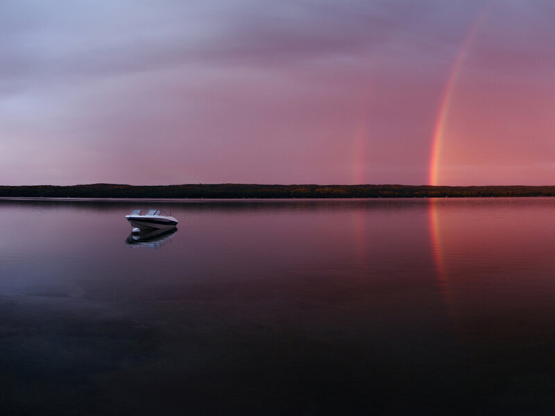 Boat on lake with rainbow