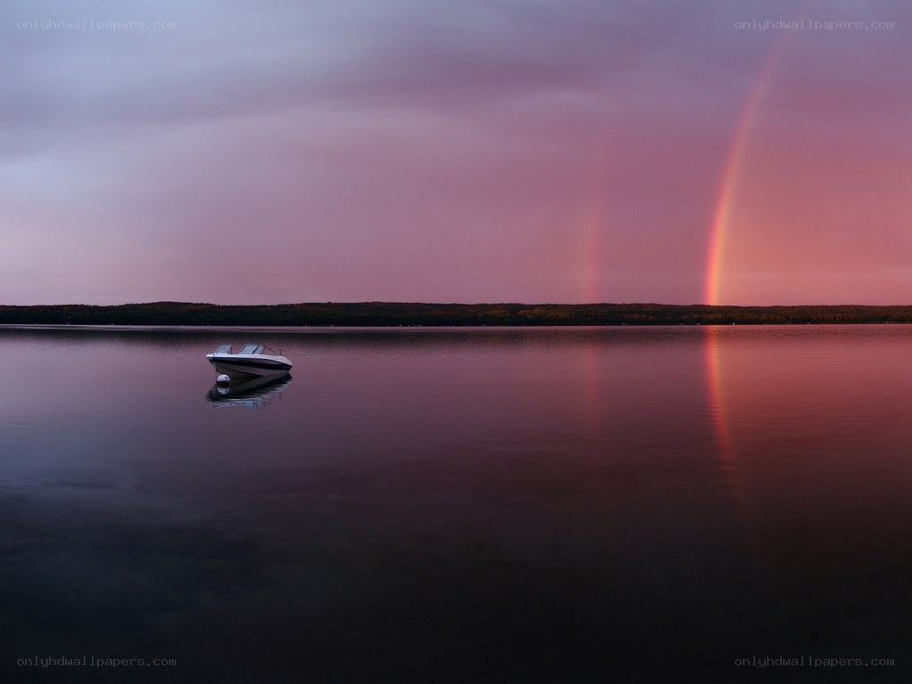 Boat on lake with rainbow