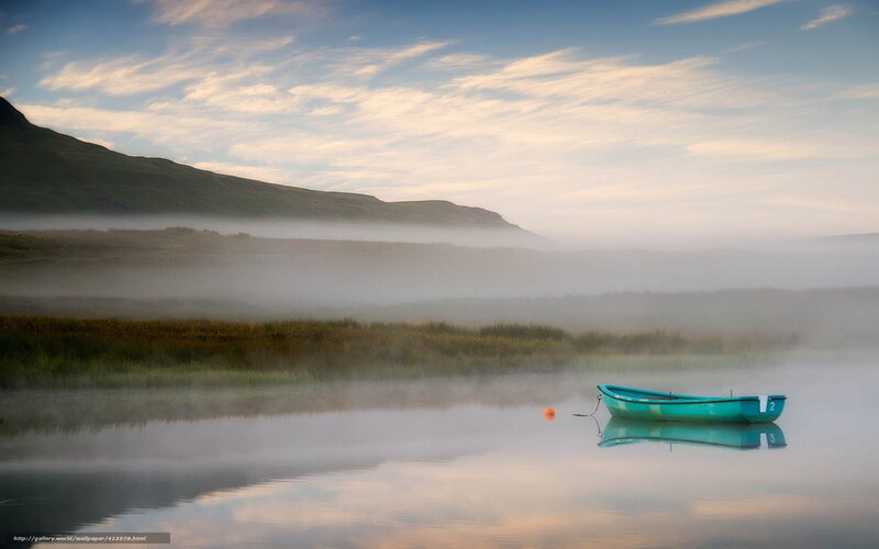 Boat on misty lake at dawn