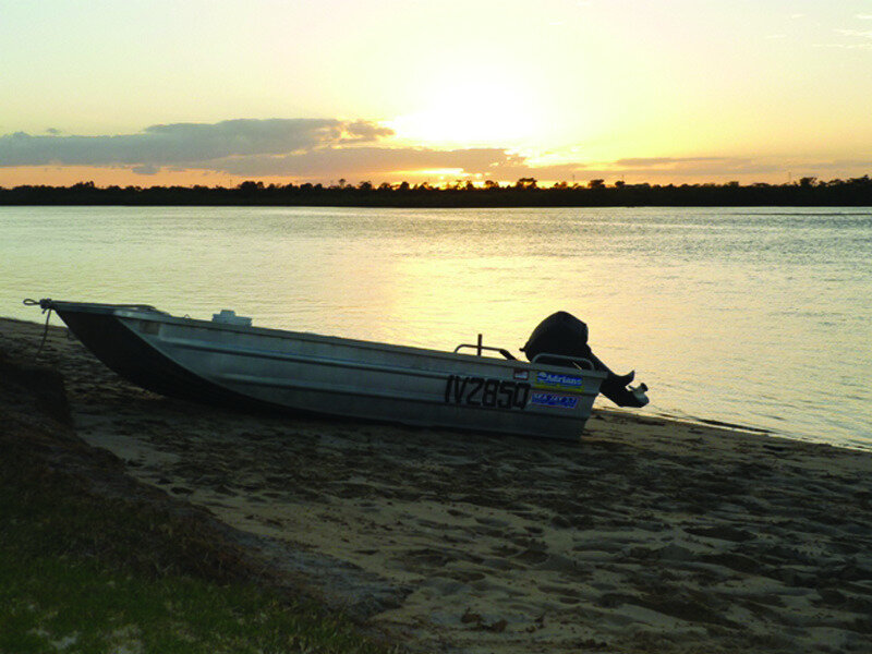 Boat on riverbank at sunset