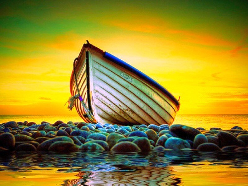 Boat on rocky shore at sunset