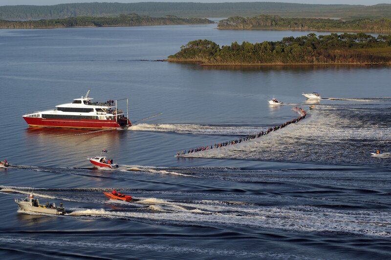 Boat pulling long line of people