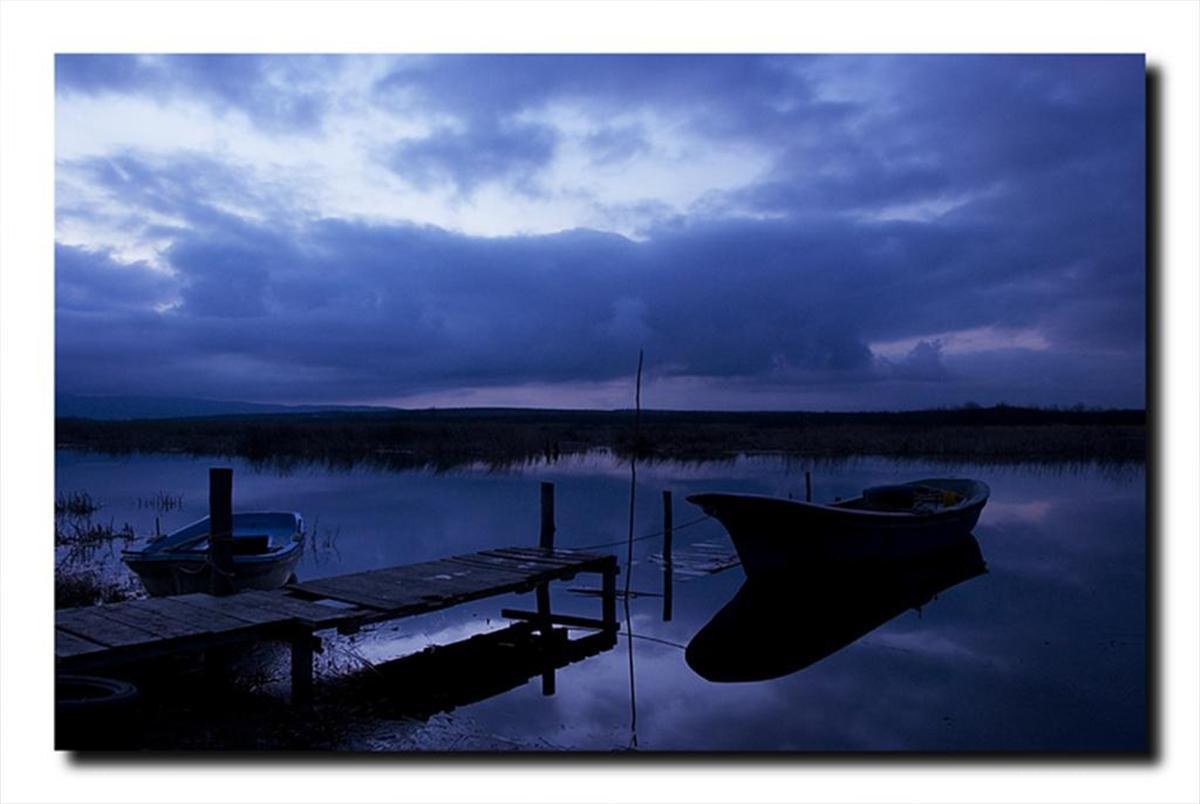Boats at a dock under stormy sky