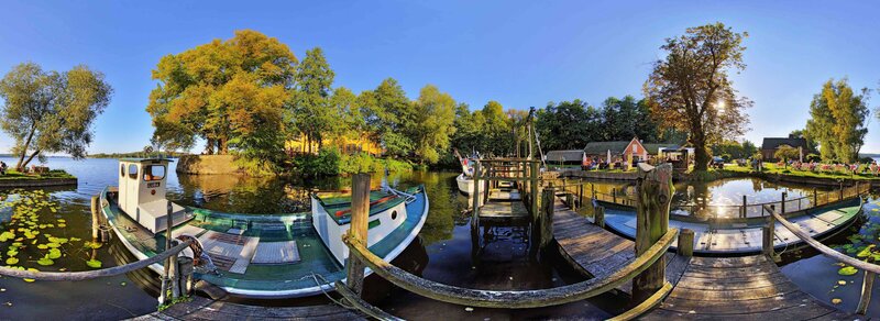 Boats at a Lakeside Dock — Blue, Serene, Afternoon, Photograph, Trees