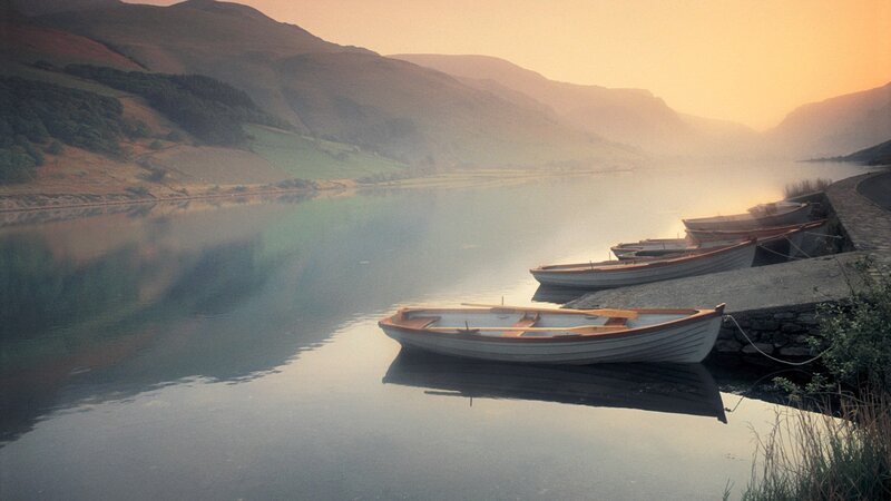 Boats at dawn on a calm lake