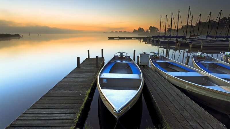 Boats at dawn on a calm lake