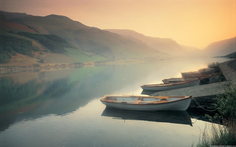 Boats at dawn on a calm lake
