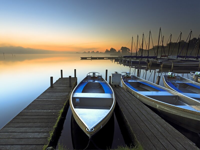 Boats at dawn on a misty lake