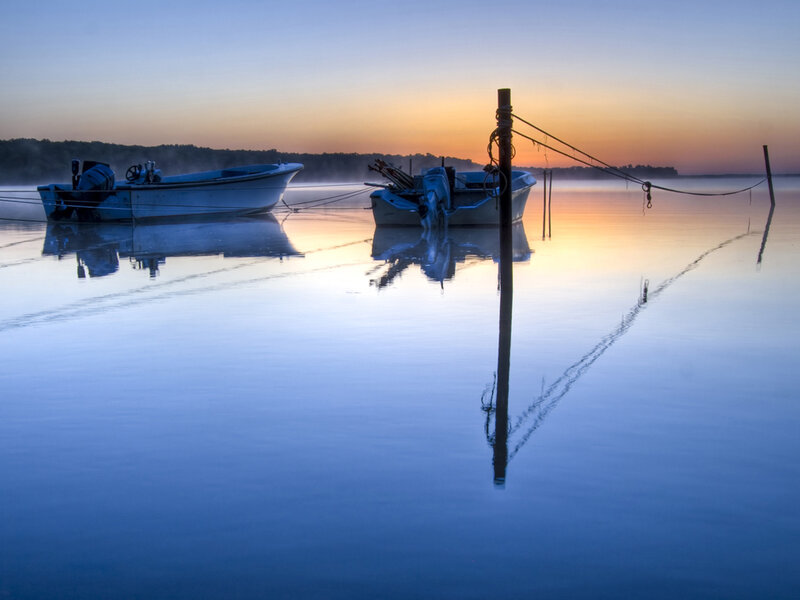 Boats at dawn on calm water