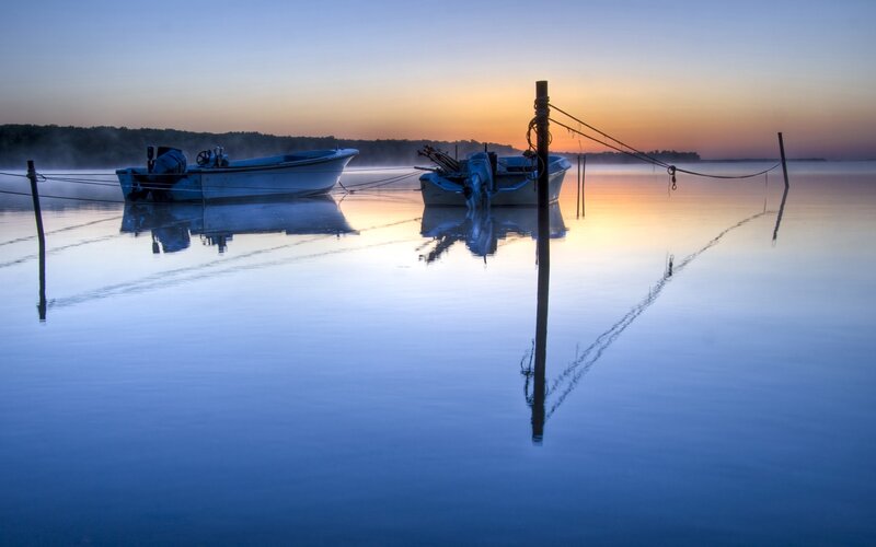 Boats at dawn on calm water