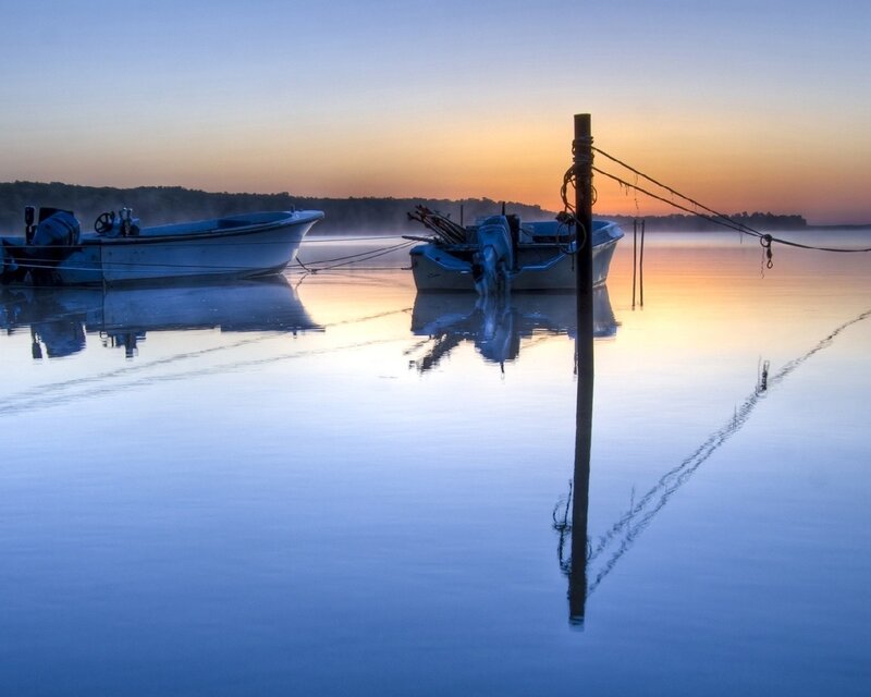Boats at dawn on calm water