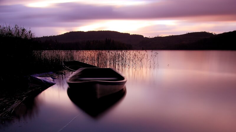 Boats at dusk on a calm lake