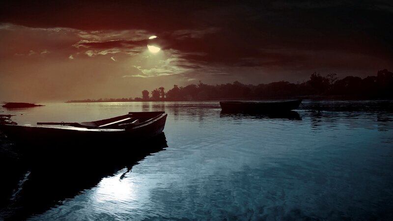 Boats at dusk on a calm lake