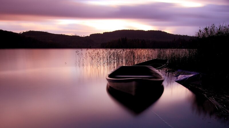 Boats at dusk on a calm lake