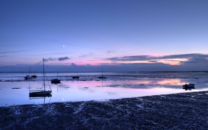 Boats at dusk on a calm shore