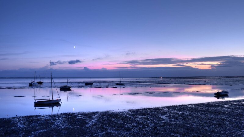 Boats at dusk on a calm shore