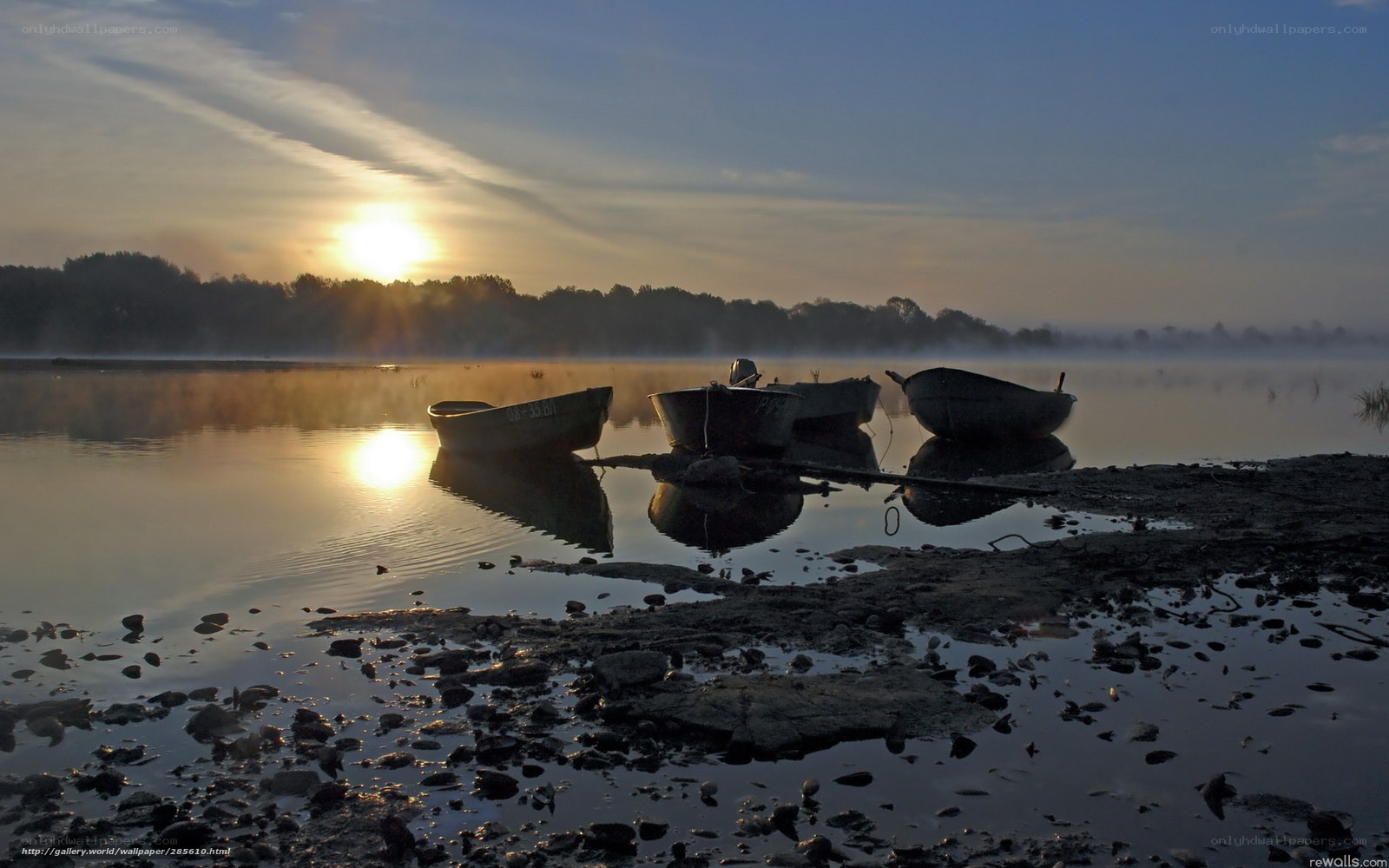 Boats at sunrise on a misty lake