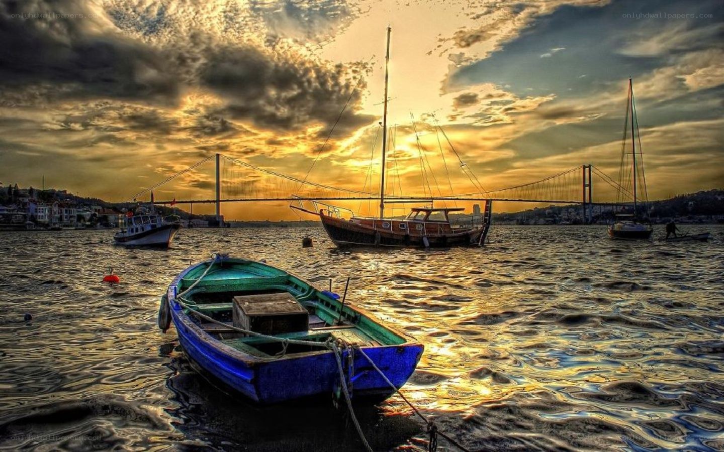 Boats at sunset by a bridge