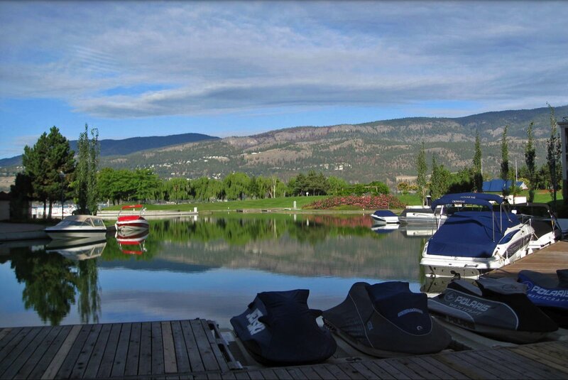 Boats docked at a lake with mountains