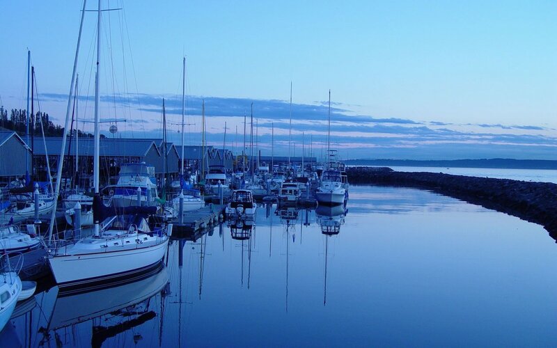 Boats docked at marina at dusk