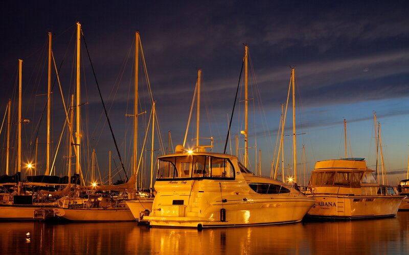 Boats docked at marina at dusk