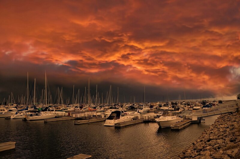 Boats docked at marina during sunset