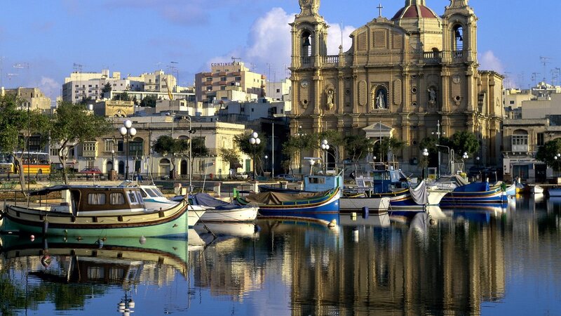 Boats in a harbor with a church