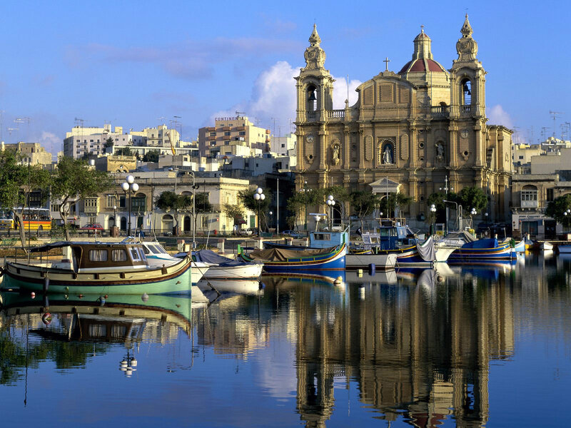 Boats in a harbor with church