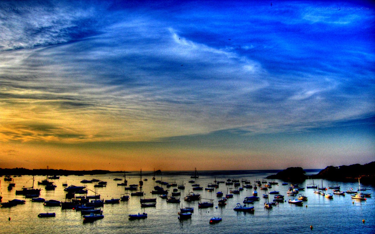 Boats in harbor at sunset
